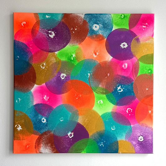 Die frontale Abbildung eines Kunstwerks in der Größe 50x50cm. Acryl auf Leinwand. Das Kunstwerk wurde ausschließlich mit Abdrücken einer Brust erschaffen. Es gibt zahlreiche Abdrücke in 8 verschiedenen Farben. Die Farben sind knallig bis neon, Gold und Kupfer.