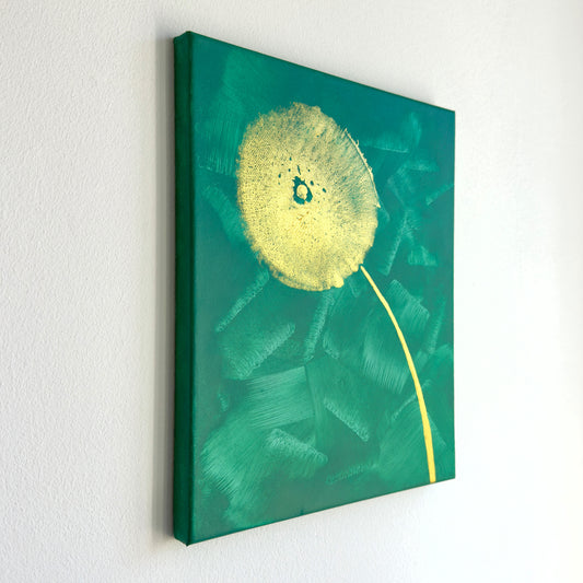 Perspektivische Aufnahme vom Kunstwerk BC #02 Acrylfarbe auf Leinwand. Das Kunstwerk zeigt eine Art Pusteblume in goldener Farbe auf einem türkisfarbenen Hintergrund. Die Blüte wurde mit der Brust gestempelt.